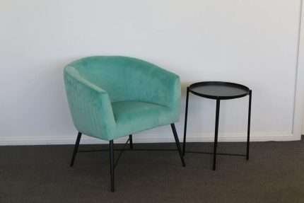 Crewe Accent Chair in Aruba Blue velvet next to a small table